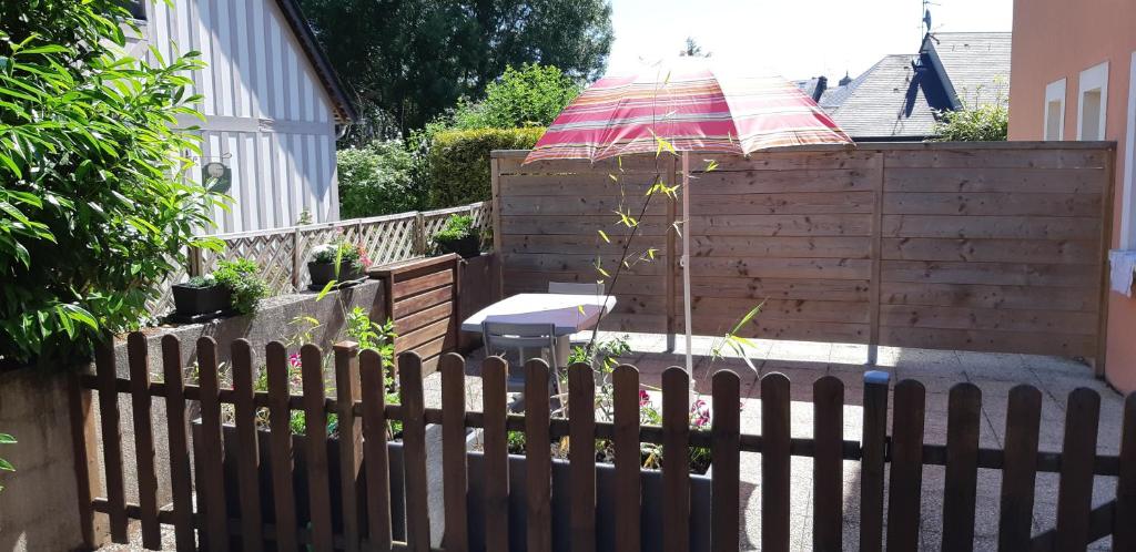 een hek met een paraplu naast een huis bij L'escale honfleuraise in Honfleur