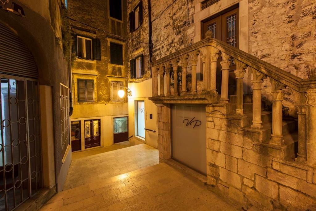 un callejón en un edificio antiguo con una escalera en Vicencin place Downtown studio apartments en Šibenik