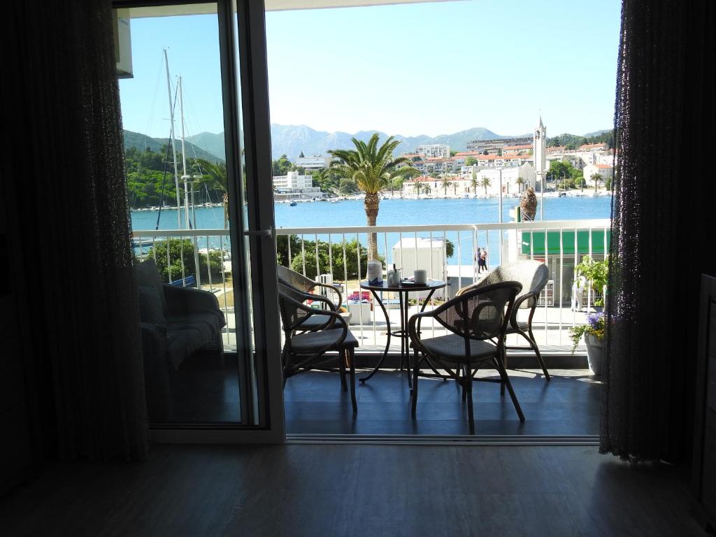 a room with a balcony with a table and chairs at Apartment Fabry Riva Ploče in Ploče