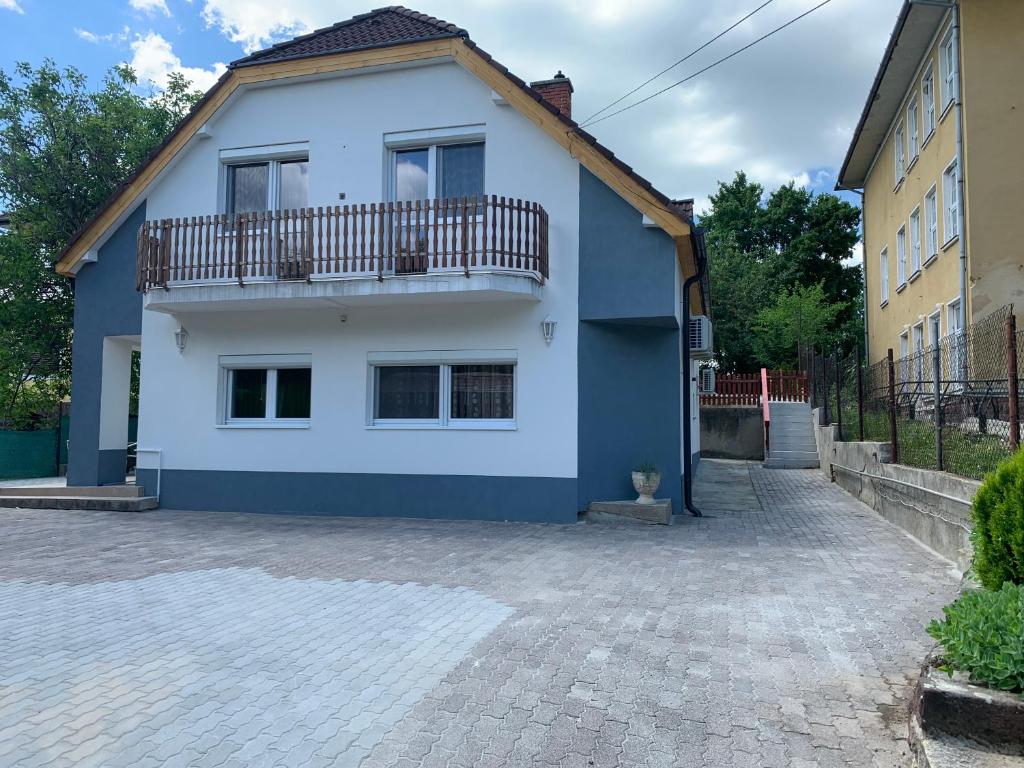 a blue and white house with a balcony at Borsi Apartman in Balatonalmádi