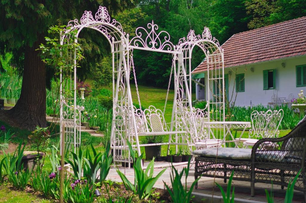 Kraljevac Križevački的住宿－Casa "Dolina Kraljevac"，花园中一组白色的大门和长椅