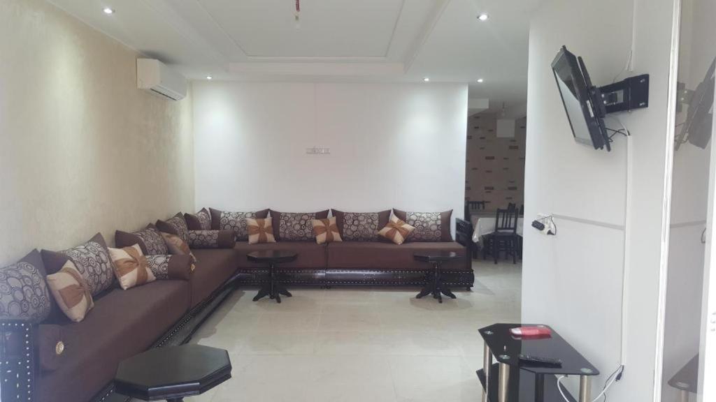 a living room with a brown couch in a room at La perle de saidia in Saidia 