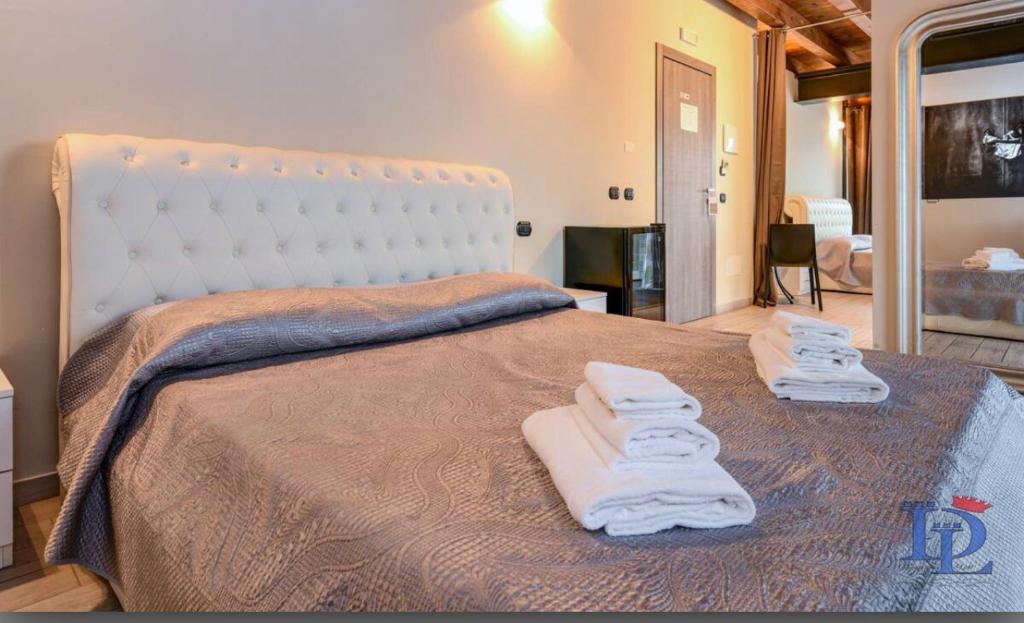 ein Schlafzimmer mit einem großen Bett mit Handtüchern darauf in der Unterkunft La Terrazza sul Lago in Peschiera del Garda