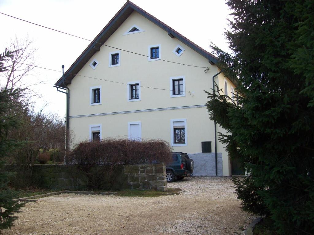 a white house with a car parked in front of it at Jaworowa Zagroda in Domaszków