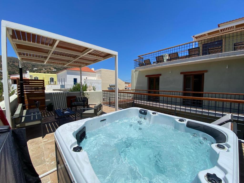 bañera de hidromasaje en el balcón de una casa en Andros 4 All Seasons Villas & Suites, en Ándros