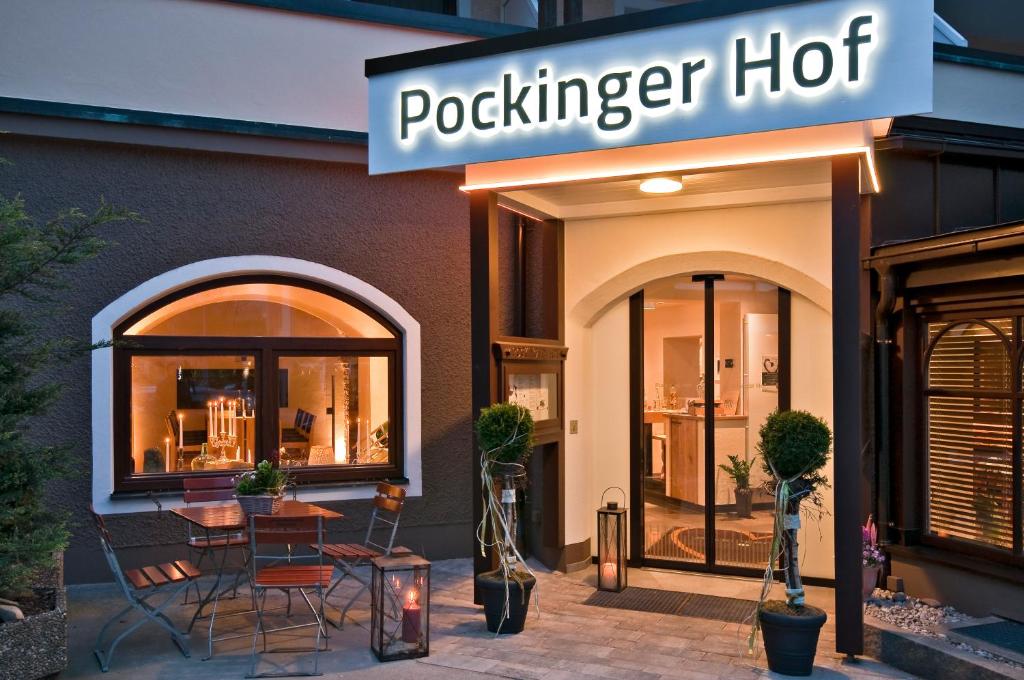 een restaurant met een tafel en stoelen voor een gebouw bij Hotel Pockinger Hof in Pocking