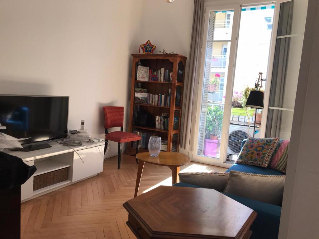 ein Wohnzimmer mit einem Sofa und einem TV in der Unterkunft Nissa la Bella in Nizza