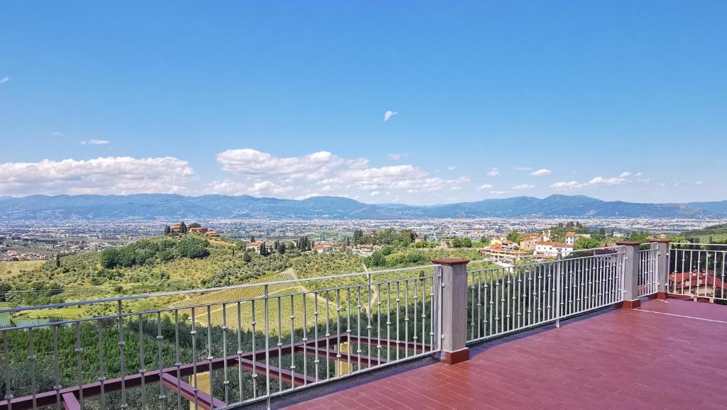 uma varanda com vista para a cidade em Agriturismo Sotto la Rocca em Carmignano