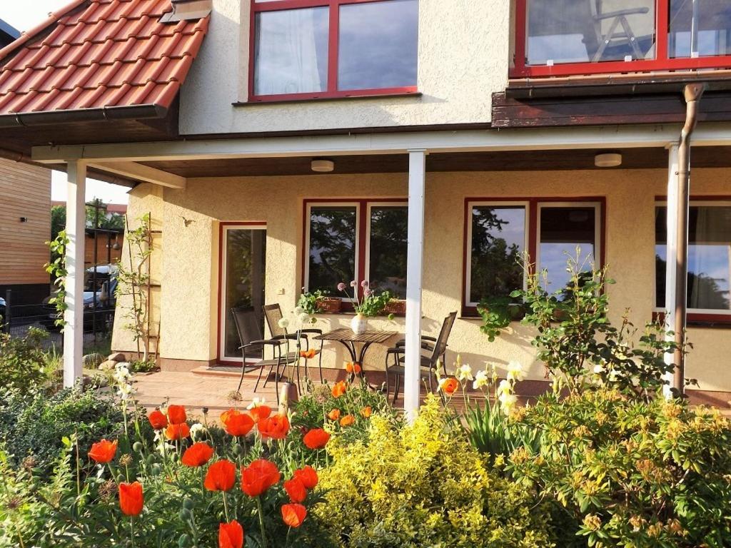 a house with a table and flowers in front of it at Ferienwohnung Petronela in Waren