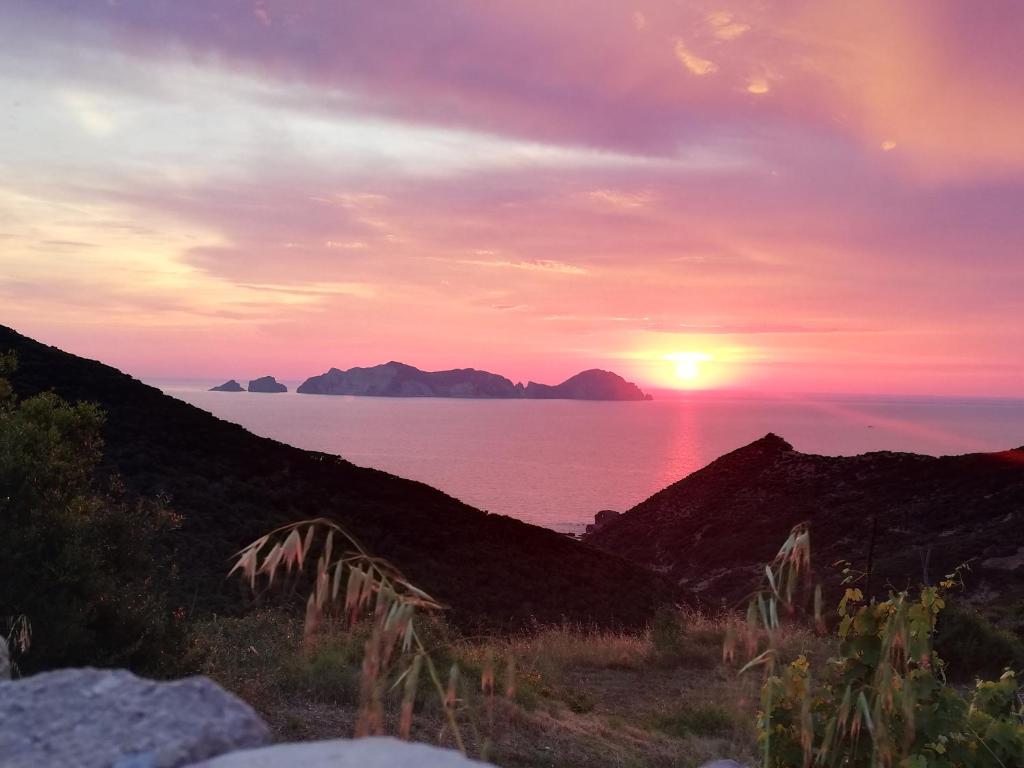 un tramonto sull'oceano con montagne sullo sfondo di Casa vacanze Ombretta a Ponza