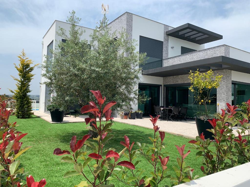 une maison avec un jardin en face dans l'établissement Casa da Colina - Villa in the Countryside, à Sobral do Parelhão