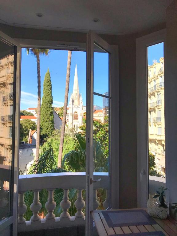 d'un balcon avec vue sur un bâtiment et des palmiers. dans l'établissement Dreamplace, à Nice