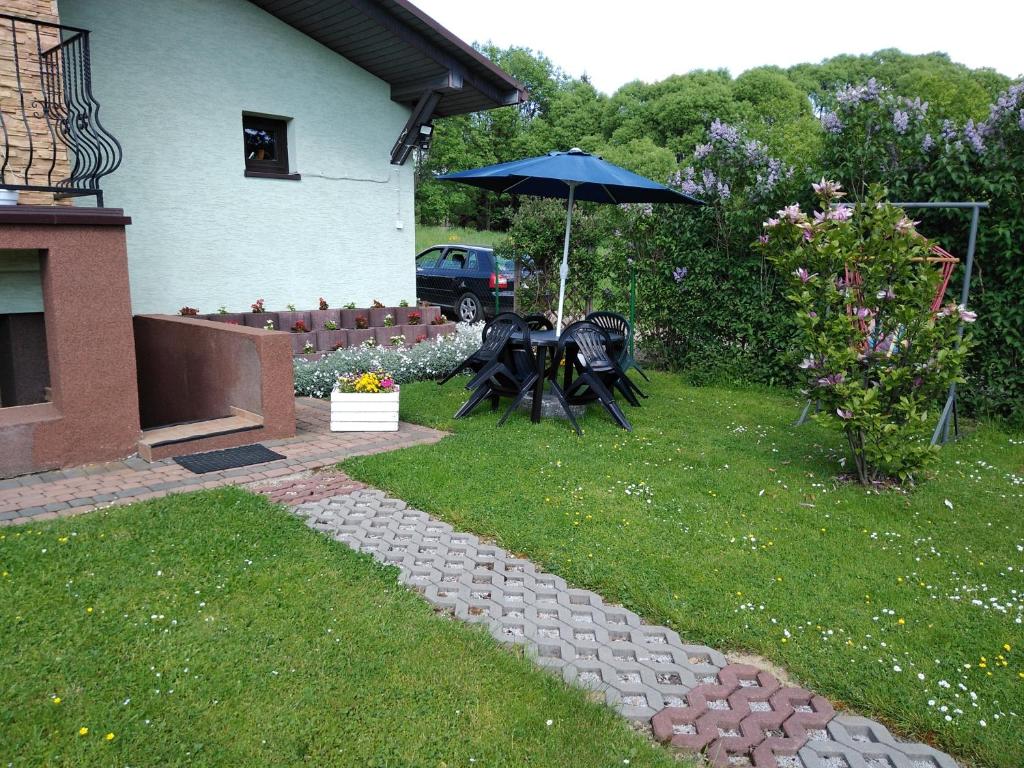 a patio with a table and an umbrella in a yard at Noclegi u Marcela in Ustrzyki Dolne