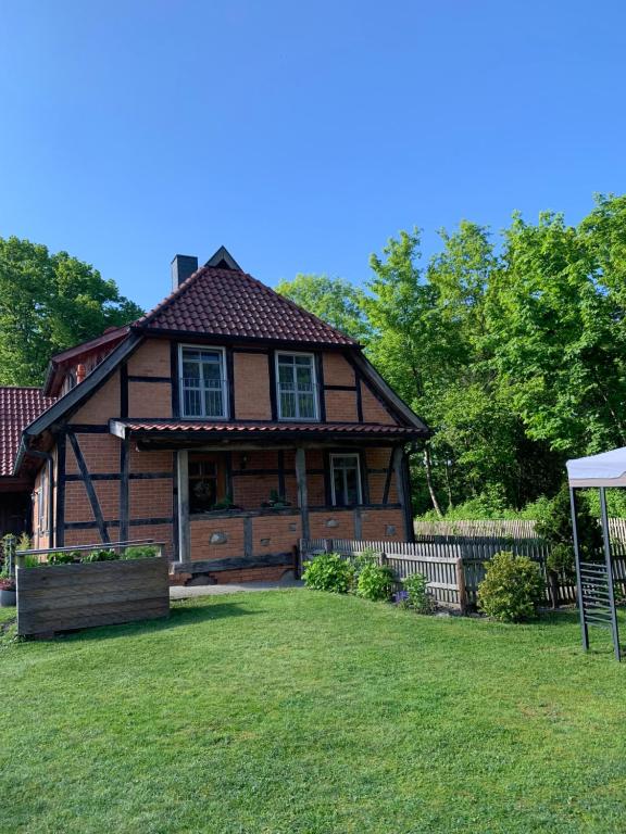 a large wooden house with a lawn in front of it at Ferienwohnung Mühlendamm in Bergen