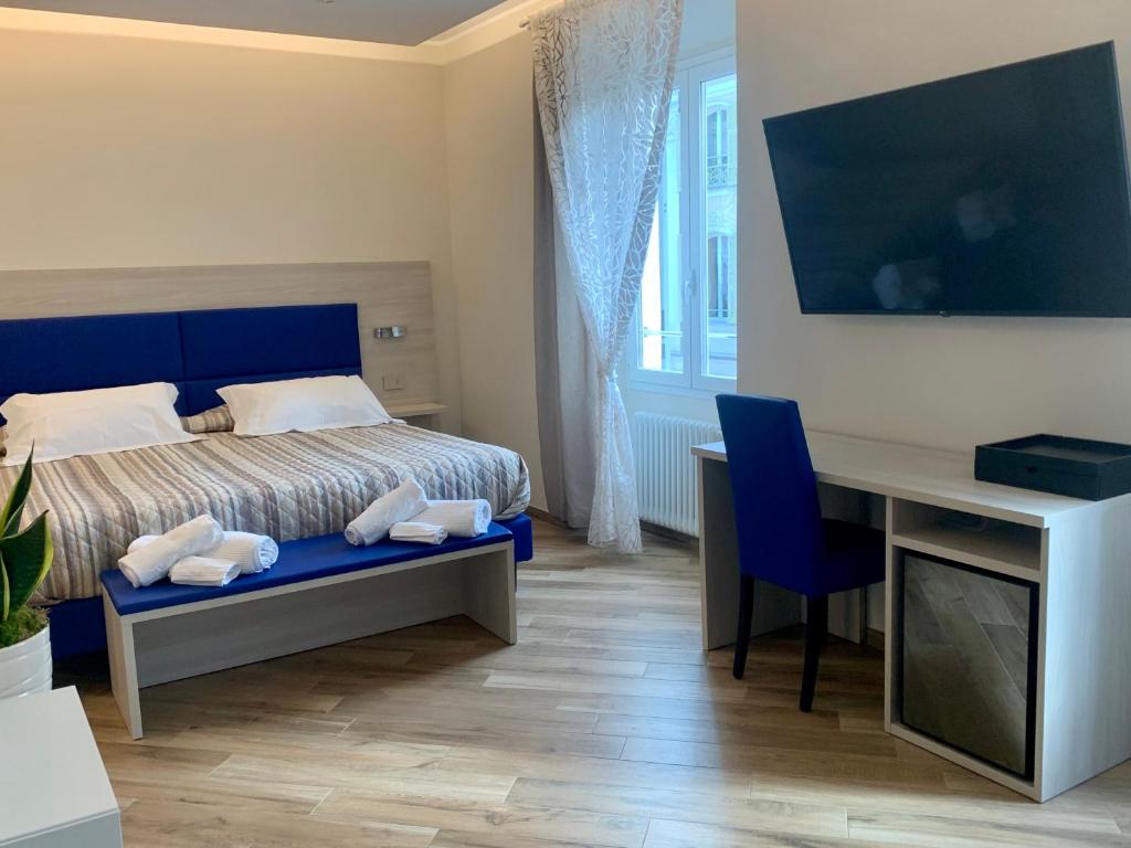 - une chambre avec un lit et un bureau avec un ordinateur dans l'établissement A Due Passi - Sanremo Apartments, à Sanremo