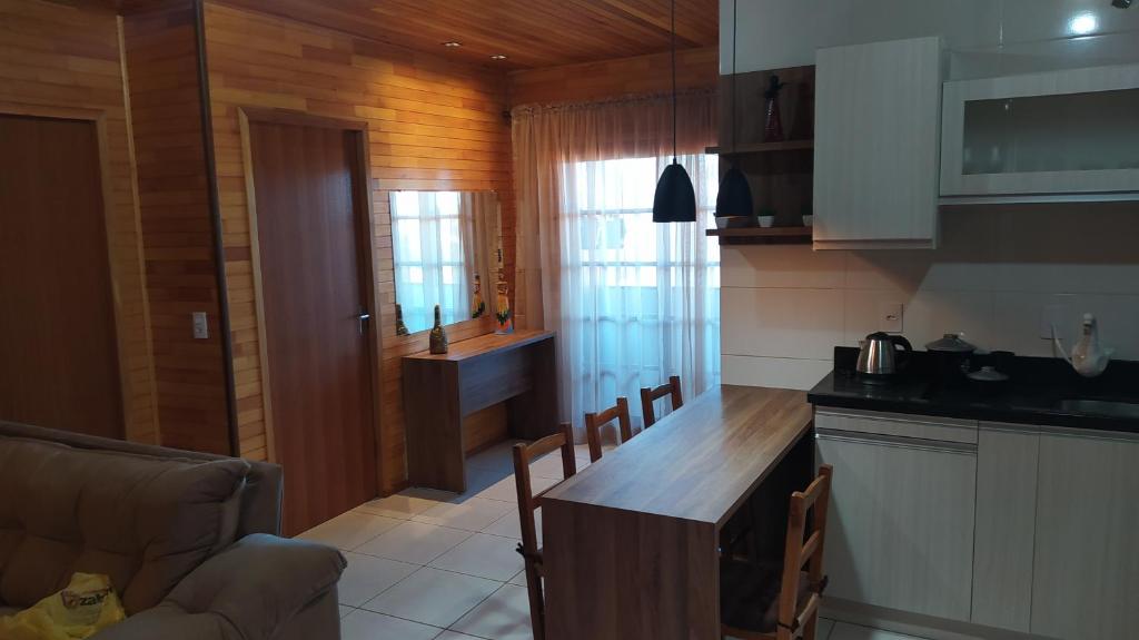 a kitchen with a counter and a table with chairs at Apartamento Serrano 2 in São Joaquim