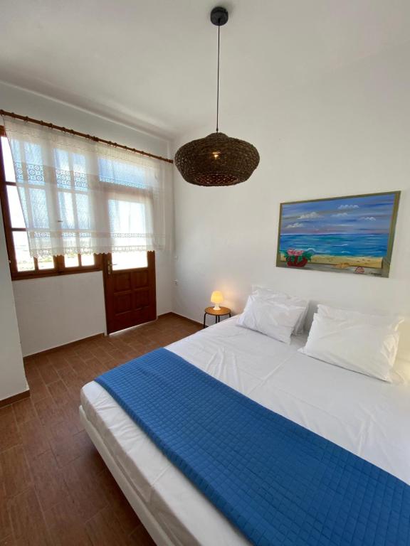 a bedroom with a large white bed with a blue blanket at Agrabely in Galanado