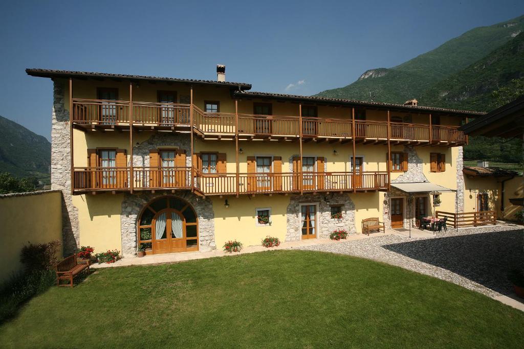 un gran edificio con balcones de madera y un patio en Agriturismo Al Picchio, en Ala