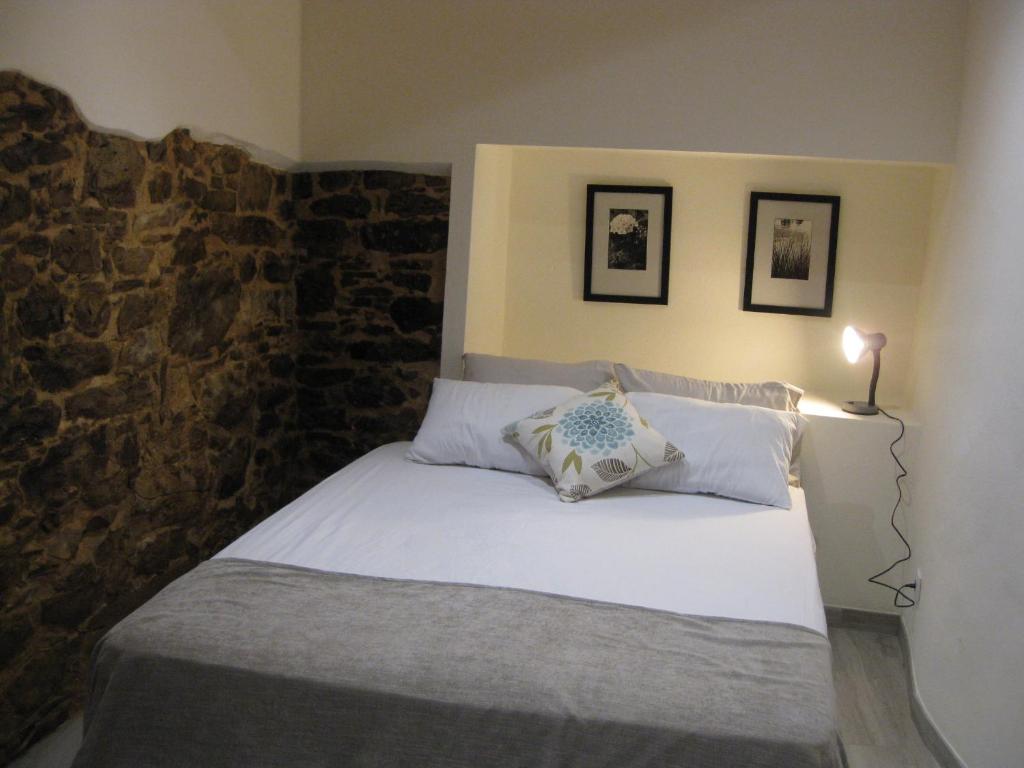 sypialnia z białym łóżkiem i kamienną ścianą w obiekcie Casa Hozani w mieście Albarrol