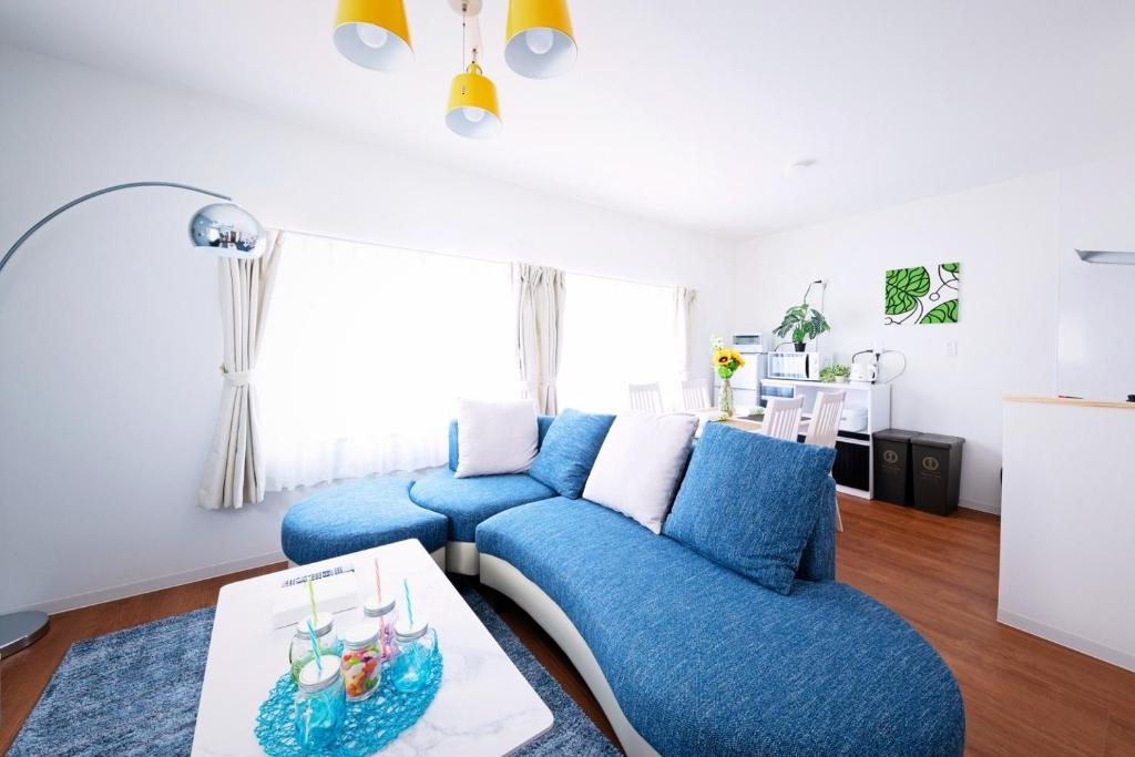 ein Wohnzimmer mit einem blauen Sofa und einem Tisch in der Unterkunft Sapporo - Apartment - Vacation STAY 7940 in Sapporo