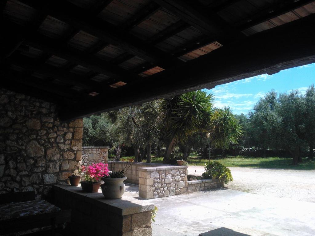a patio with potted plants and a stone wall at Agriturismo Salento Pietralata in Andrano