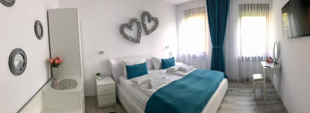 a bedroom with a blue and white bed and a bathroom at Gizell Apartment 1 in Sibiu