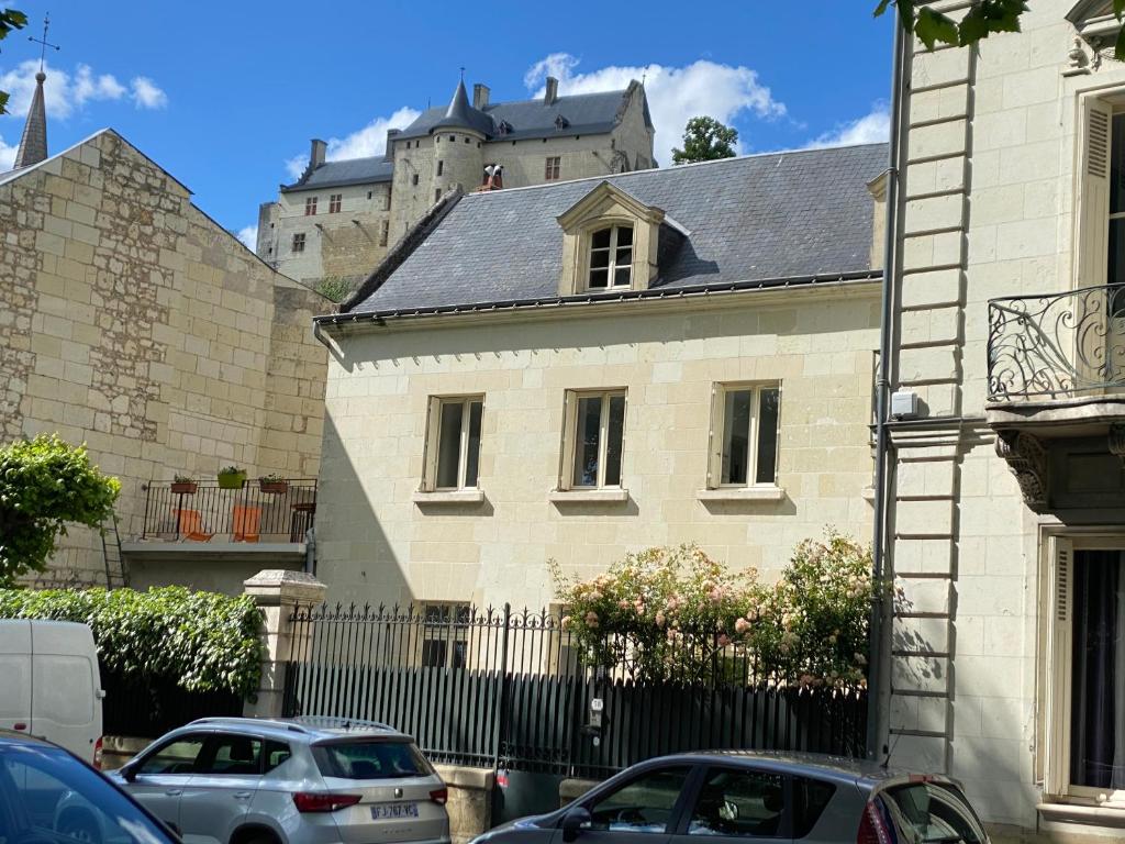 a white house with a castle in the background at Le Charles VII in Chinon