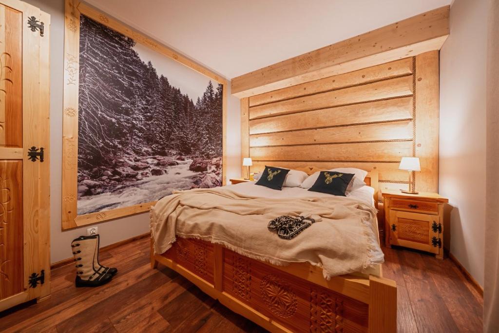 Schlafzimmer mit einem großen Bett mit einem Kopfteil aus Holz in der Unterkunft Olczańska Kotlina Apart&Room in Zakopane