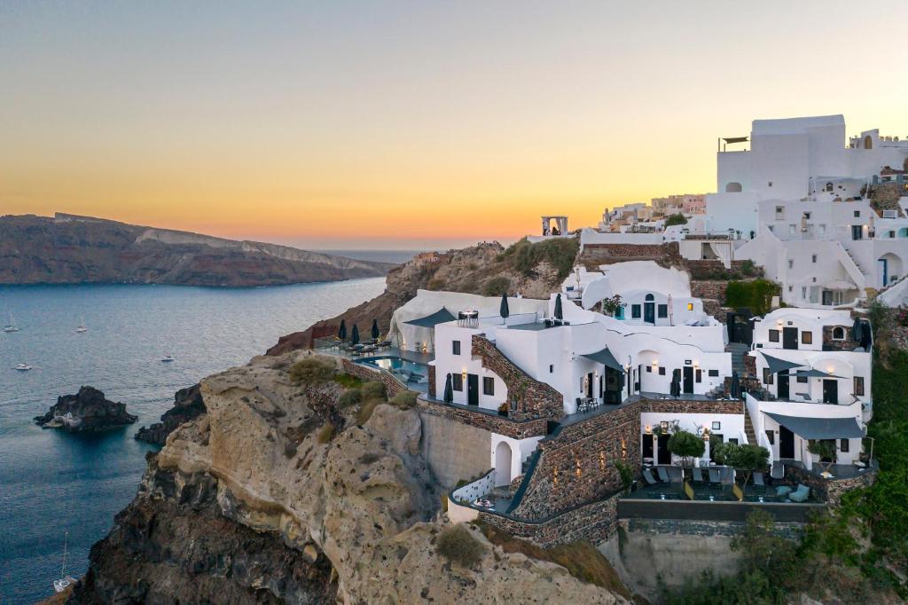 a group of white houses on a cliff at Pearl of Caldera Oia - Boutique Hotel by Pearl Hotel Collection in Oia