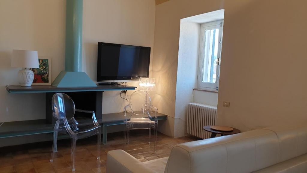ein Wohnzimmer mit einem Sofa und einem Tisch mit einem TV in der Unterkunft Al Duomo Relais in Matera