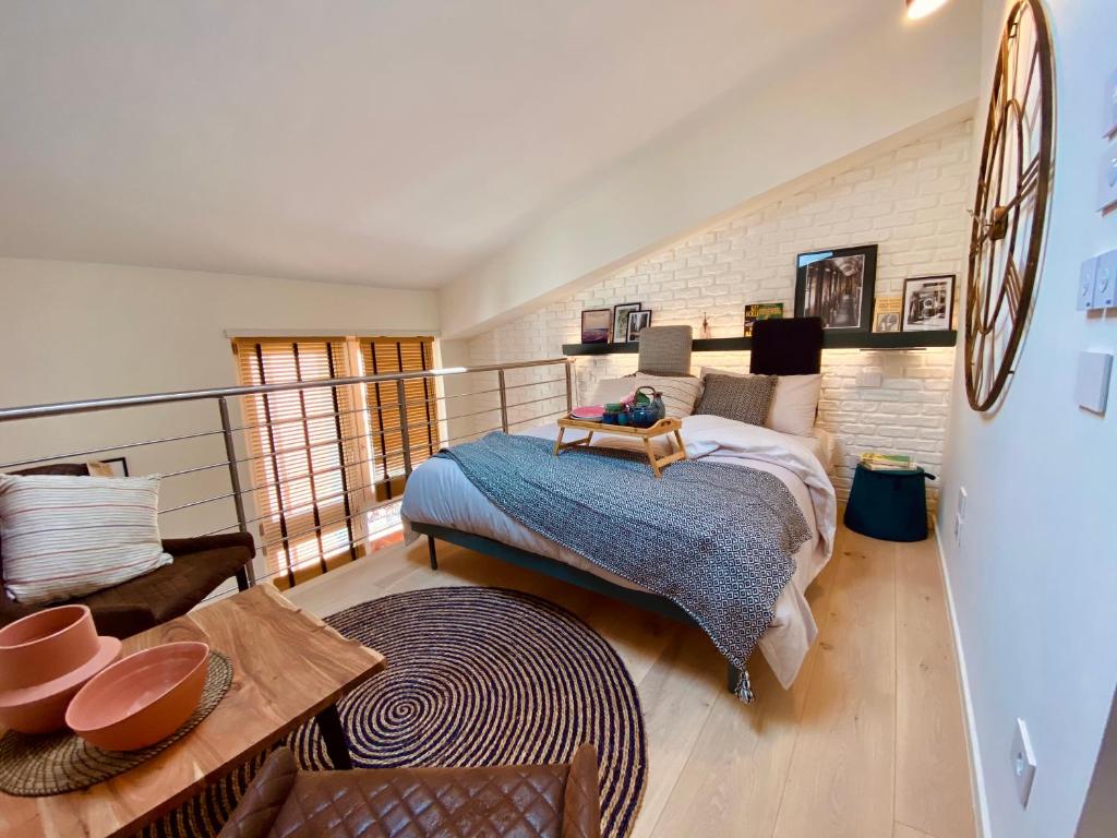 ein Schlafzimmer mit einem Bett und einem Tisch darin in der Unterkunft Volto Corte Farina Apartments - Luxury Lofts in Verona