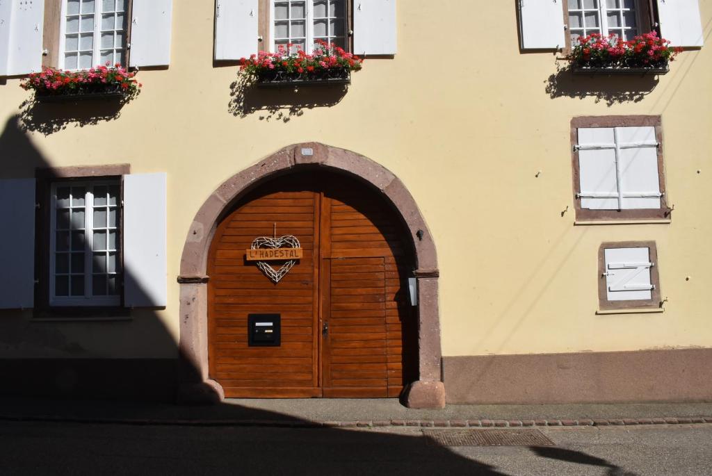 a building with a wooden door with flowers on it at L'Hadestal in Hattstatt