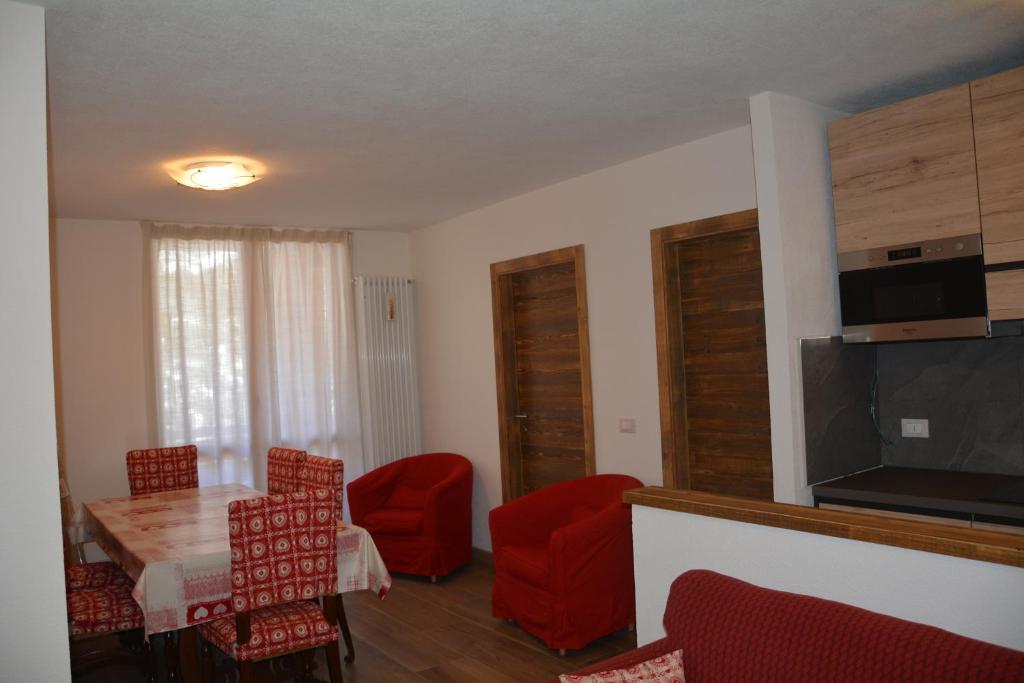 een woonkamer met een tafel en rode stoelen bij Casa Sonia in Canazei