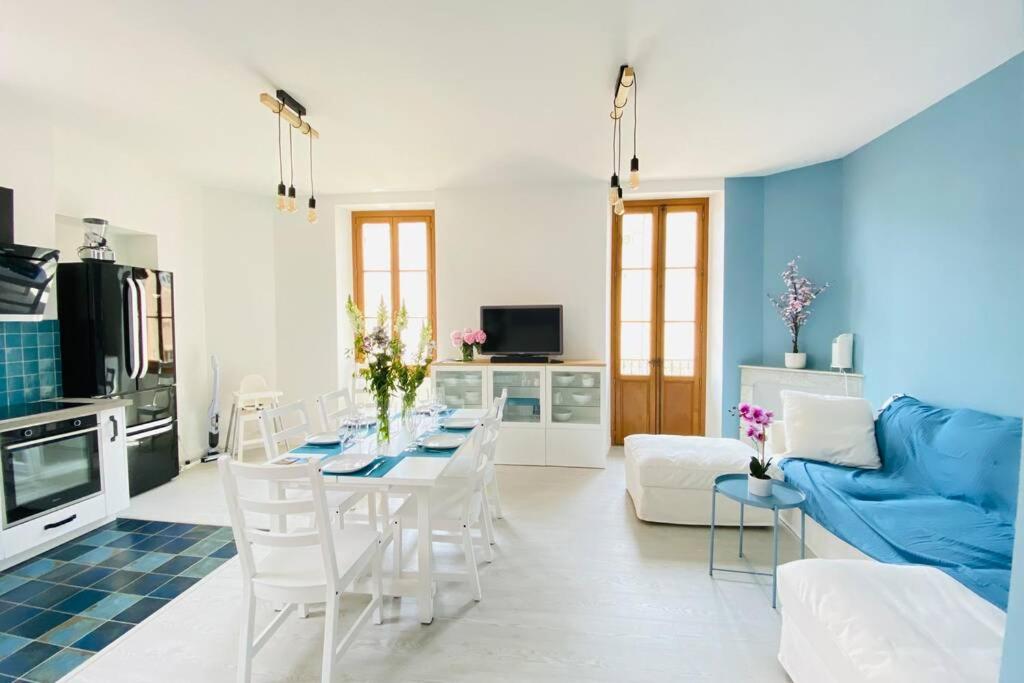 un salon avec une table et un canapé bleu dans l'établissement Grand appartement proche plages & centre ville, à Cannes
