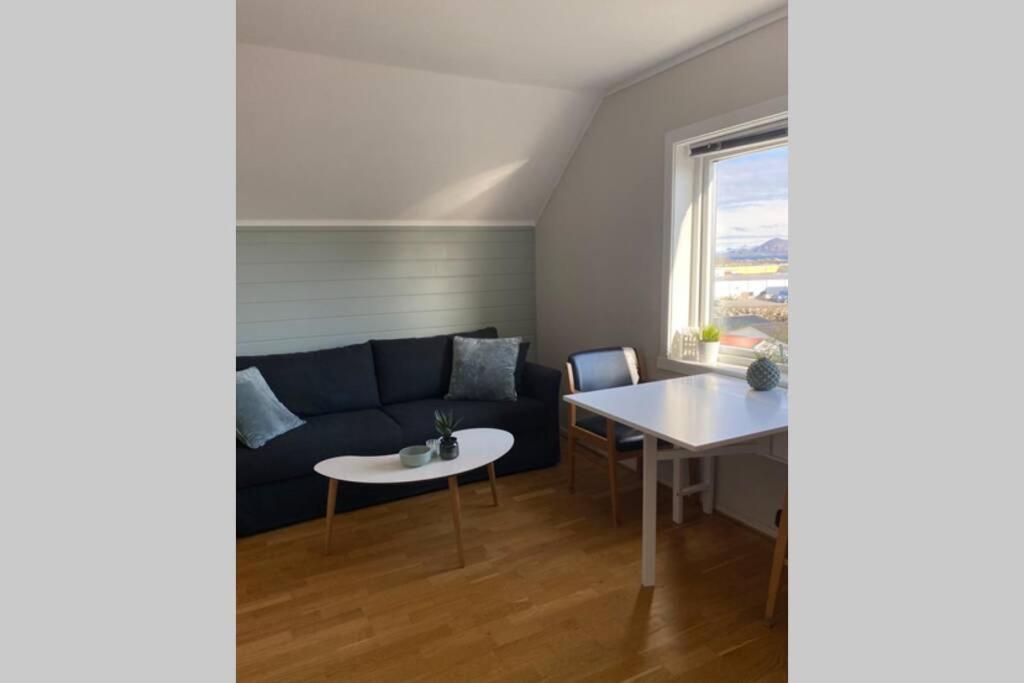 een woonkamer met een bank en een tafel bij Koselig leilighet sentralt i Svolvær in Svolvær