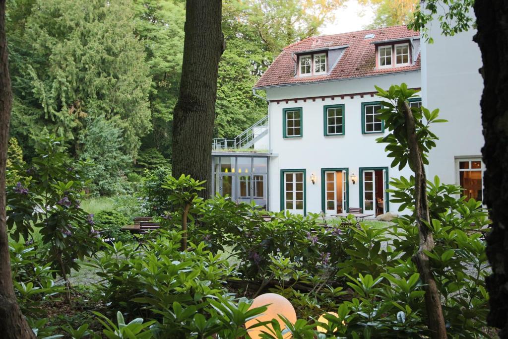 a house in the woods with trees at Hardtwald Hotel in Bad Homburg vor der Höhe