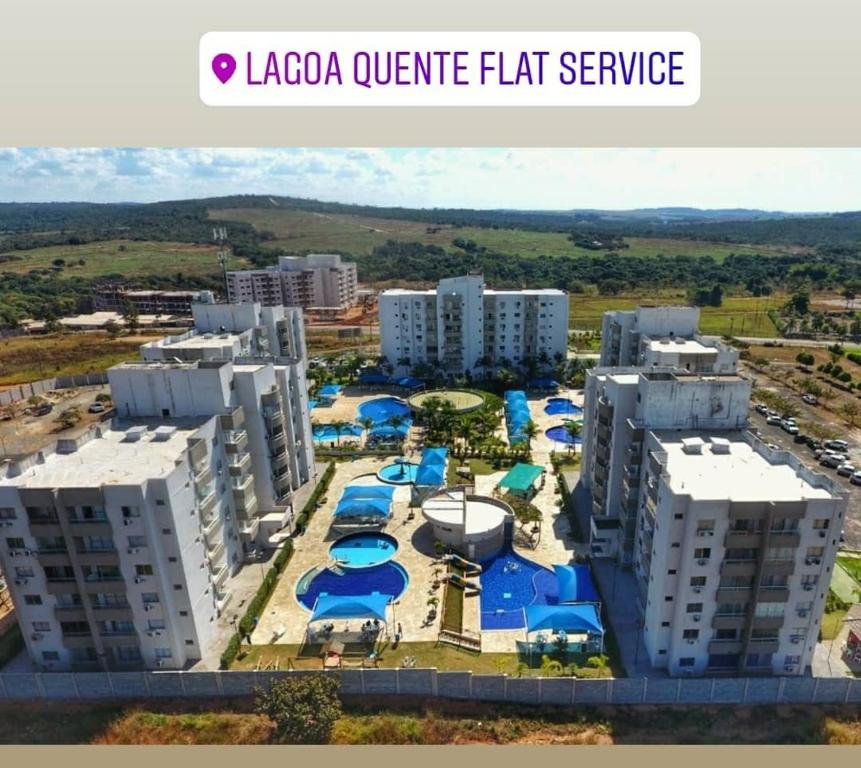 an image of a large apartment complex with blue umbrellas at Condomínio Lagoa Quente Flat Service-Caldas Novas - FLAT TOP in Caldas Novas