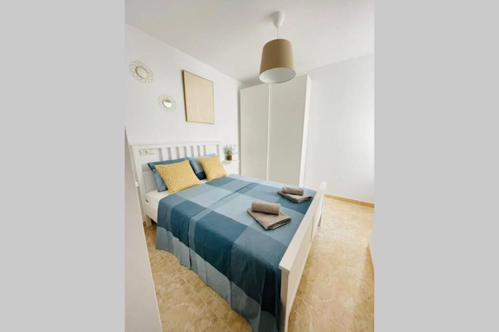 - une chambre blanche avec un lit bleu dans l'établissement UIM Mediterraneo Poeta 2 Wifi, à Puerto de Sagunto