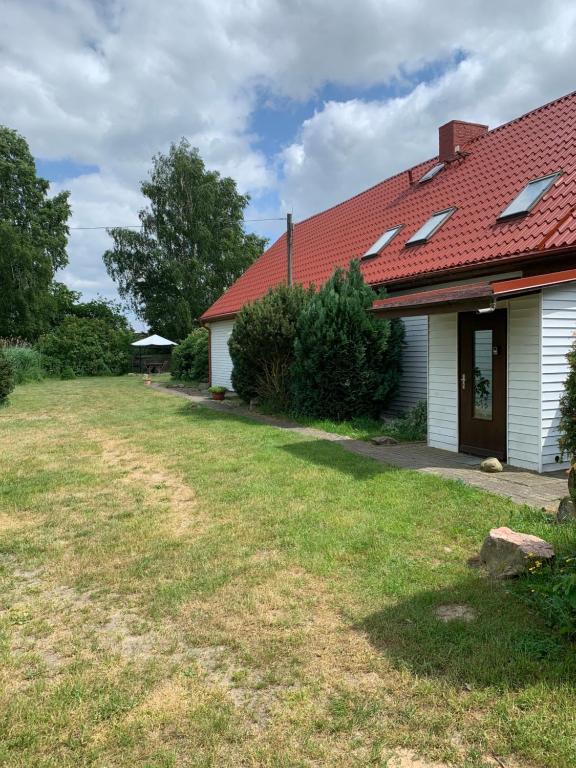 a house with a red roof and a yard at Useinseldom in Katschow