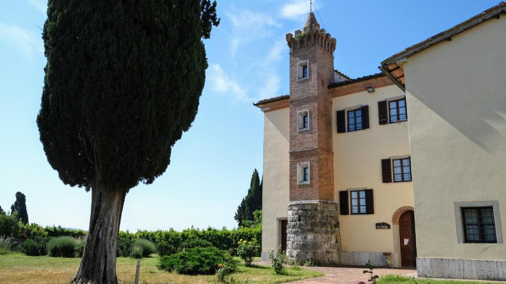 un edificio con un albero di fronte di Villa Brignole a Montaperti