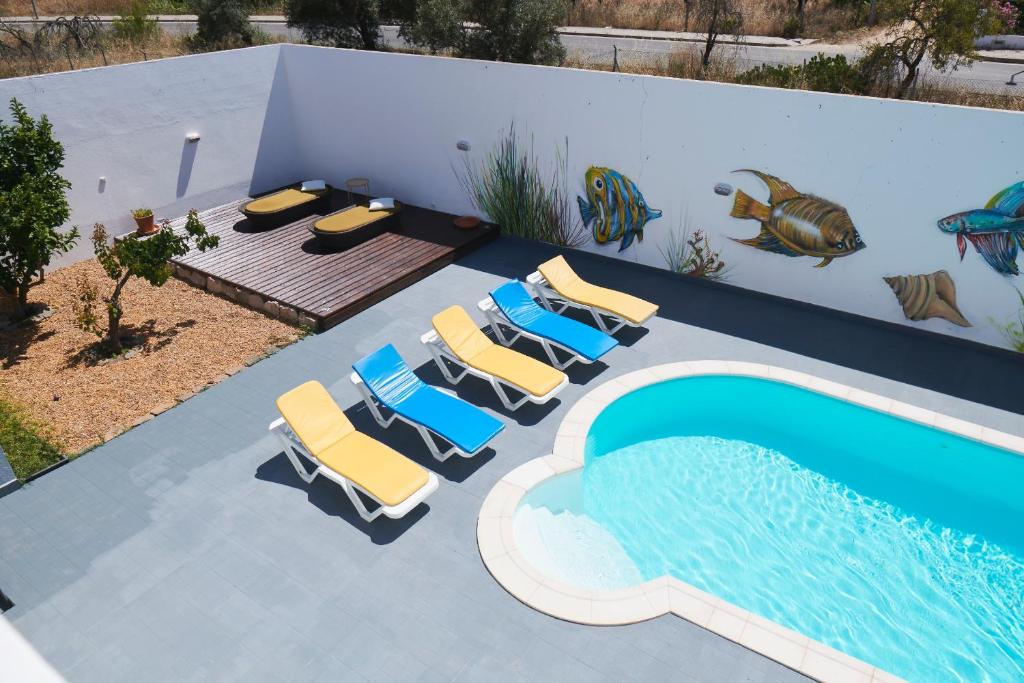 a pool with lounge chairs and a swimming pool at Villa Lua Mar in Fuzeta