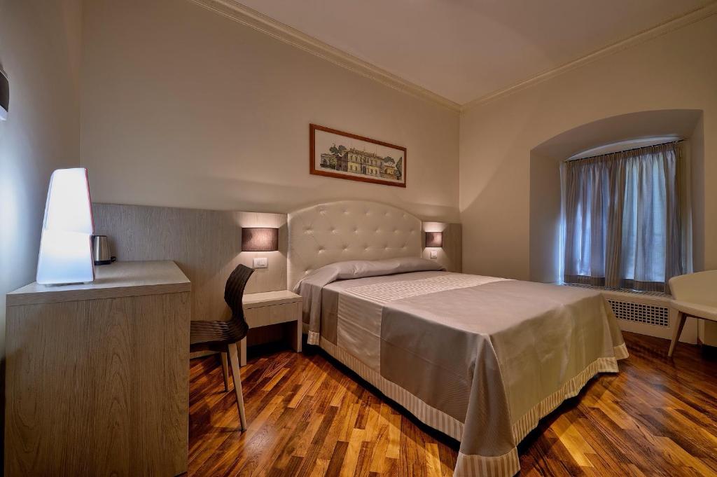 sypialnia z łóżkiem, biurkiem i stołem w obiekcie Polinari Rooms San Pietro Roma w Rzymie