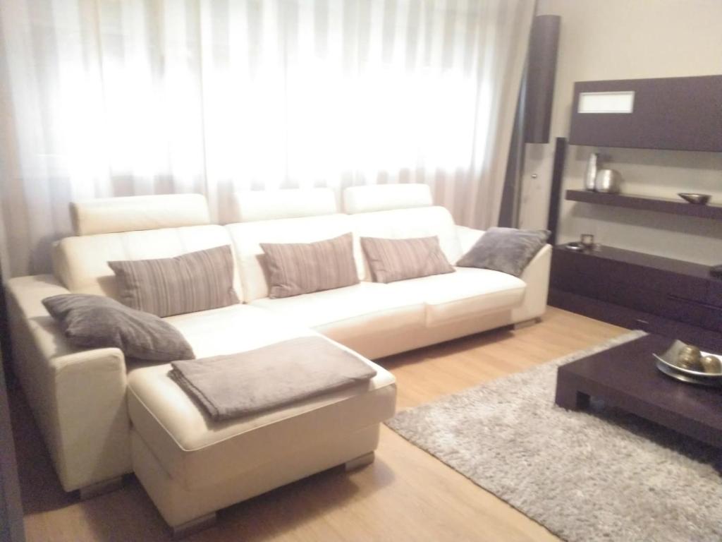sala de estar con sofá blanco y ventana en Casa Pimen, en Gijón