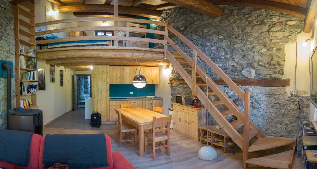 桑佩雷的住宿－AlfaBaita，厨房设有木桌和螺旋楼梯。