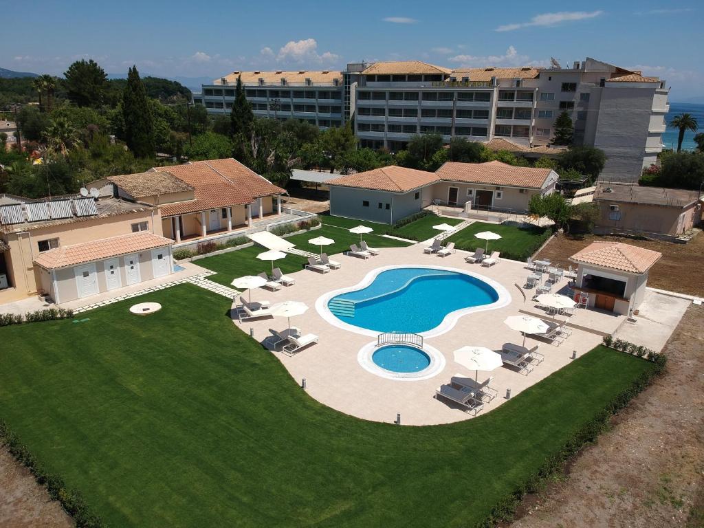 una vista sul soffitto di una piscina con sedie e ombrelloni di Santos Holidays a Dassia