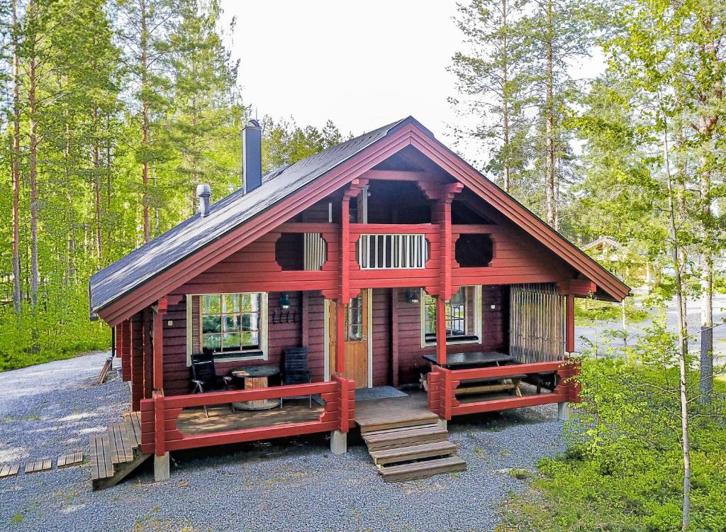 eine kleine Hütte im Wald mit einer Veranda und einer Treppe in der Unterkunft Kuhahuvila, Kalajärvi, Maatilamatkailu Ilomäen mökit in Peräseinäjoki
