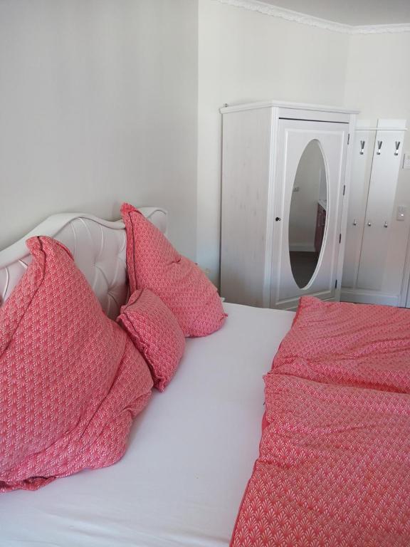 a white bed with pink pillows and a mirror at Boutique-Hotel Villa Rosali in Hamburg