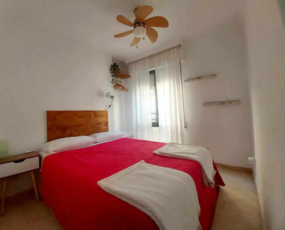 マラガにあるCasa Salamancaのベッドルーム1室(赤いベッド1台、天井ファン付)