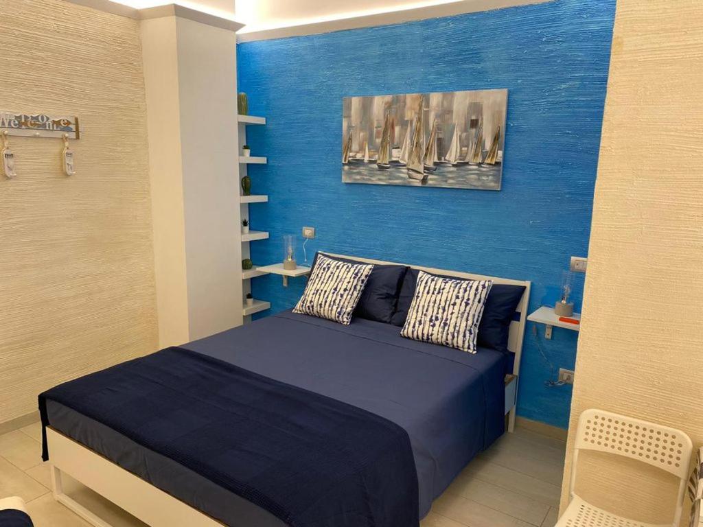 um quarto azul com uma cama e uma parede azul em ARIA DI SALE ROOM em Margherita di Savoia