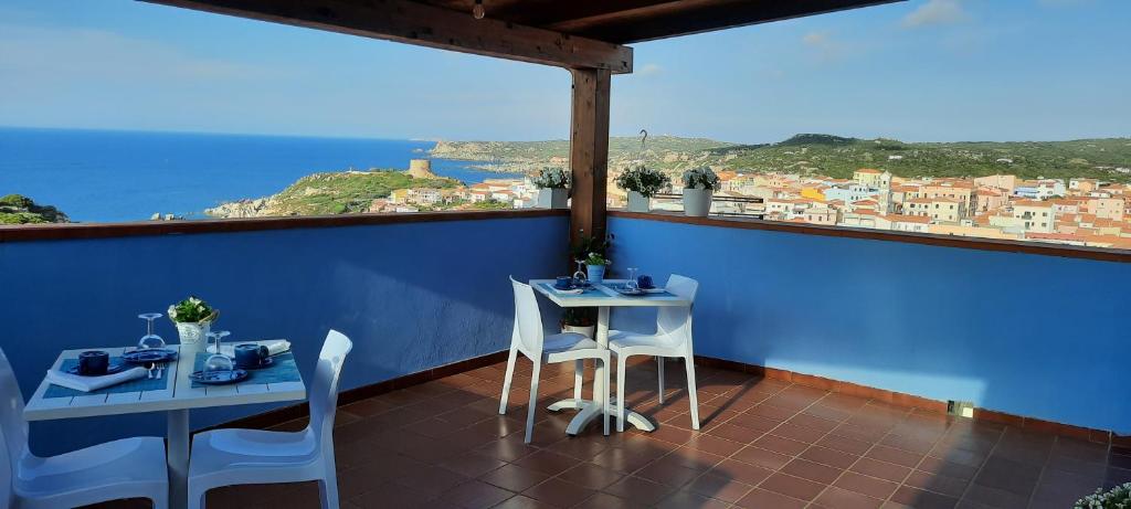 balcón con 2 mesas y vistas a la ciudad en B&B Monte Becco en Santa Teresa Gallura